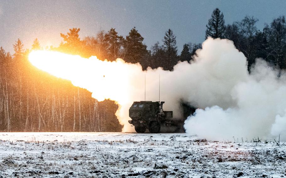 A photo of a bright light and trail of smoke erupting from a HIMARS.