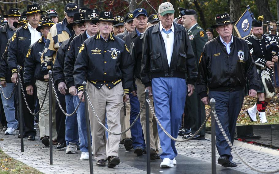 Medal of Honor recipient Ed “Too Tall” Freeman, front center, Hal Moore, front left, and Joe Galloway lead a group of Ia Drang battle survivors during a 2005 ceremony at the Vietnam Veterans Memorial in Washington in 2005.