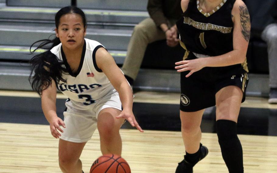 Osan’s Margaux Edquid dribbles against Humphreys Black’s Madison Bridges during Saturday’s DODEA-Korea girls basketball game, won by the Cougars 34-30.