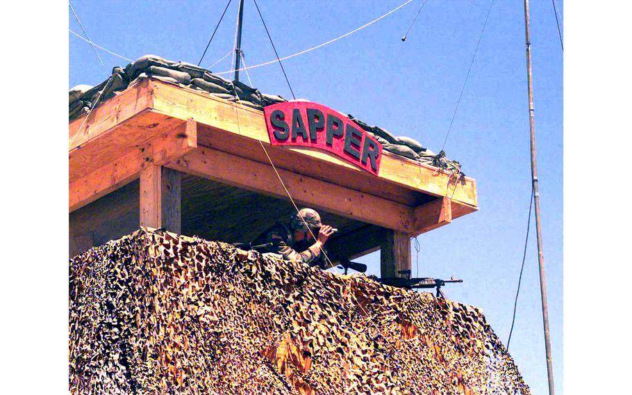 Pvt. 2 Charles Cheney, 1st Battalion,  36th Regiment, looks through his binoculars at the sector surrounding Check Point Sapper, Kosovo, July 6, 2000.