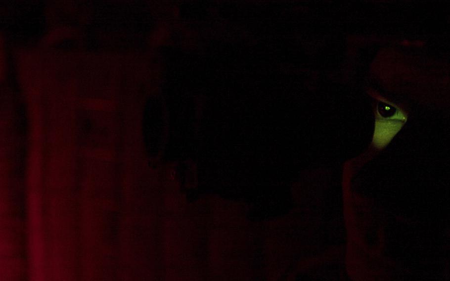The glow of night vision goggles is seen on a U.S. Army soldier, July 5, 2011, in Kunar province, Afghanistan. Two men who forged deep bonds of friendship while serving in the Army in Afghanistan would be arrested in 2018 for a scheme to steal weapons and explosives from an armory at Fort Bragg, North Carolina, and sell them. 