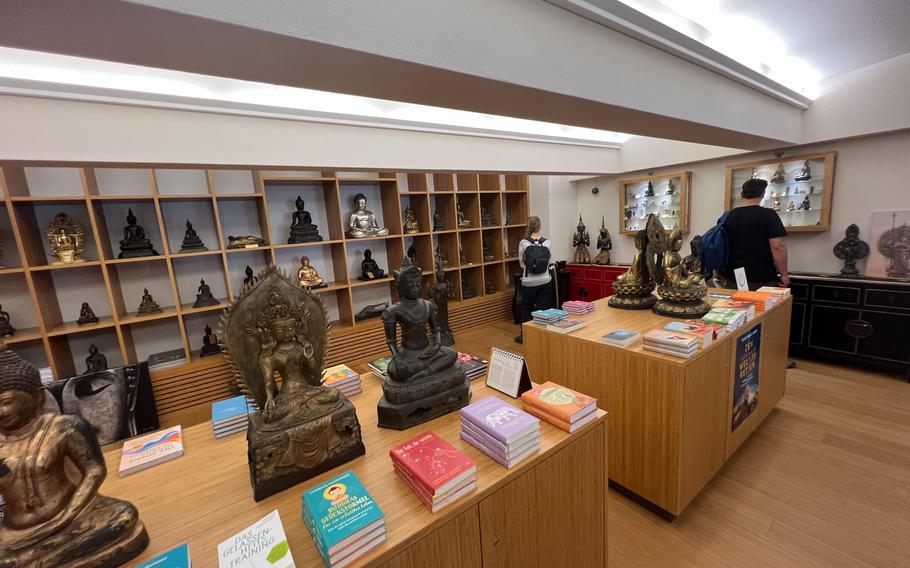 Visitors peruse books and statues for sale at the Buddha Museum in Traben-Trarbach, Germany, June 11, 2022. Many of the purchase offerings are far from tourist gimmicks and some are collectible antiques.