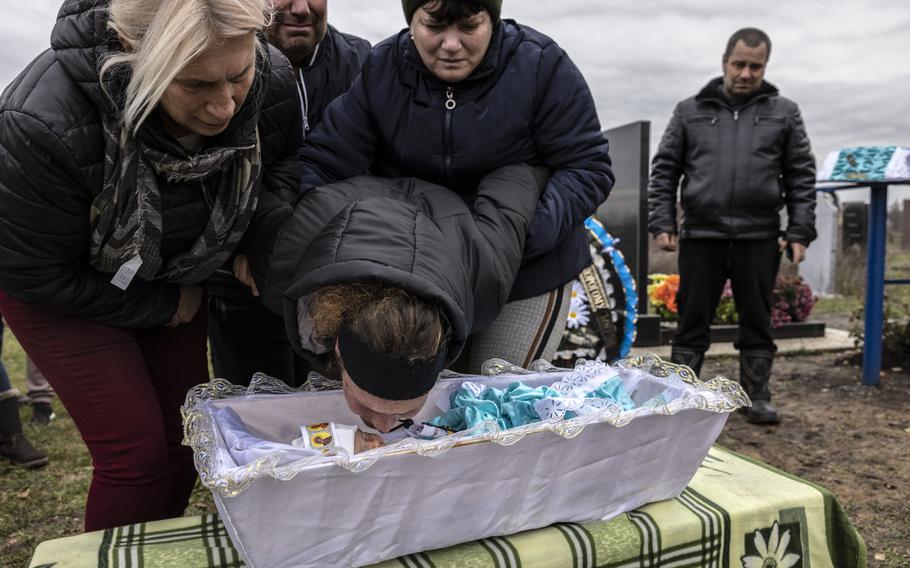 Maria Kamianetska kisses her baby’s face Nov. 24 as her mother, Tetiana Svystunova, and her sister Lyuba hold her. The boy was killed less than 48 hours after his birth in a Russian missile attack that devastated a maternity unit of a hospital in the Zaporizhzhia region. 