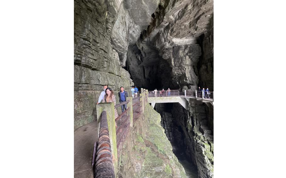 Tourists pass over a bridge above where the Qing River flows through Tenglong Cave, near Lichuan in China's Enshi prefecture. 