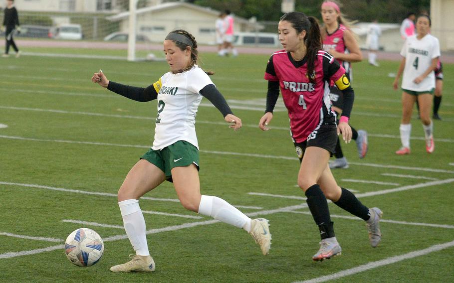 Kubasaki's Erika Samluk boots the ball ahead of Kadena's Yume Catlett during Wednesday's Okinawa girls soccer match. The Dragons won 1-0.