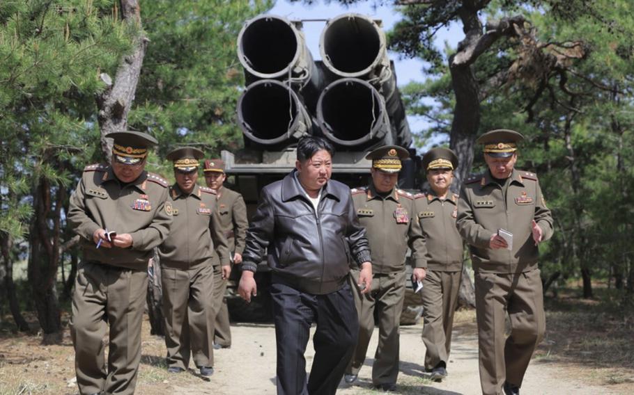 Kim Jong Un walks with North Korean military members.