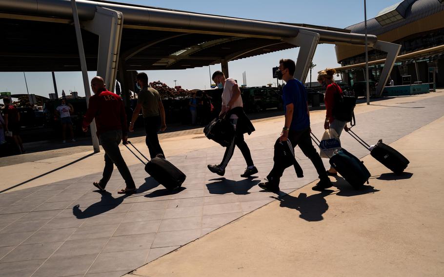 Tourists wheel luggage from the arrivals terminal at Faro Airport in Faro, Portugal, on May 29, 2021.