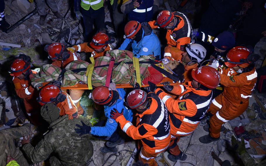 Ece Koseoglu, 25, is placed on a stretcher by rescuers after being removed from under the rubble of a collapsed building following two massive back-to-back earthquakes that affected Turkey and Syria, in Antakiya, Turkey, on Feb. 10, 2023. 