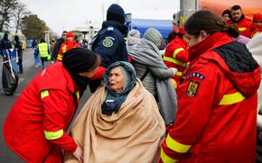 Emergency Situations Department employees talk to wheelchair bound Katia, 90 years-old, a refugee fleeing the conflict from neighbouring Ukraine at the Romanian-Ukrainian border, in Siret, Romania, Saturday, March 5, 2022.