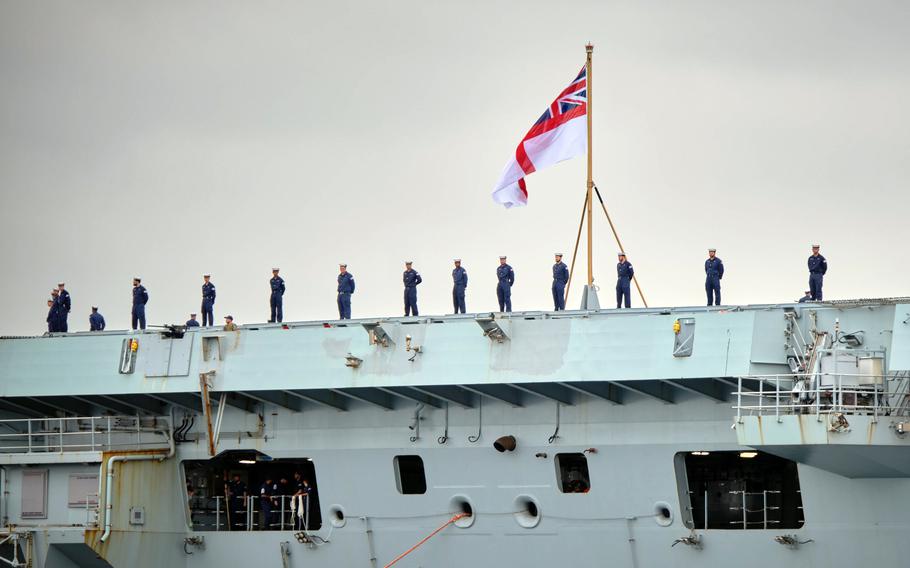 Royal Navy sailors man the rails of the HMS Queen Elizabeth as the aircraft carrier arrives at Yokosuka Naval Base, Japan, Saturday, Sept. 4, 2021. 