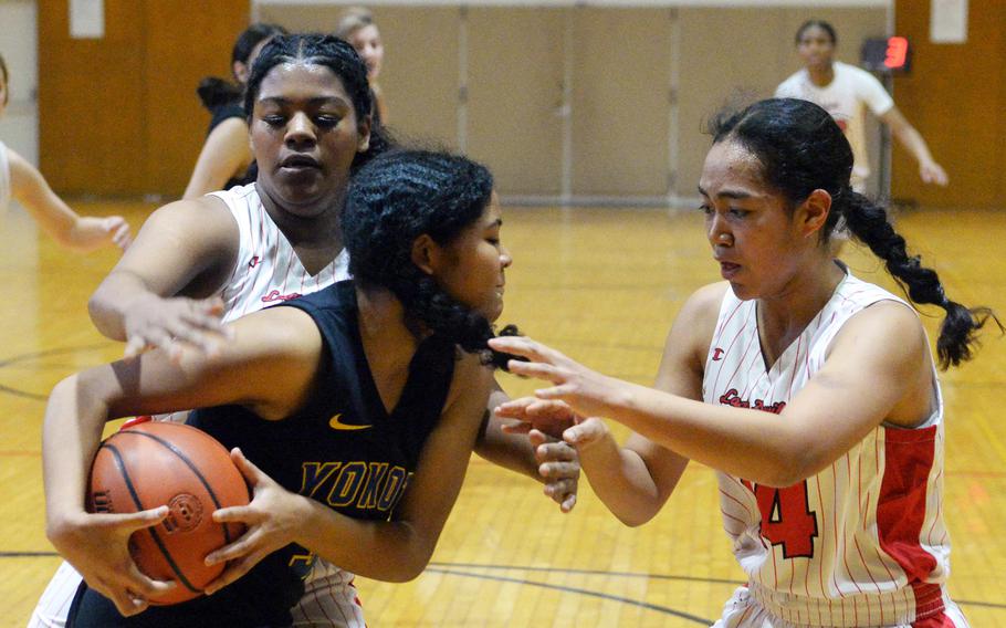 Yokota's Ayea Brown gets bottled up by Nile C. Kinnick's Michele Holloway and Kotone Turner during Friday's ASIJ Kanto Classic quarterfinal. The Red Devils won 40-15 to remain unbeaten at 16-0. They face Okkodo of Guam in Saturday's semifinal.