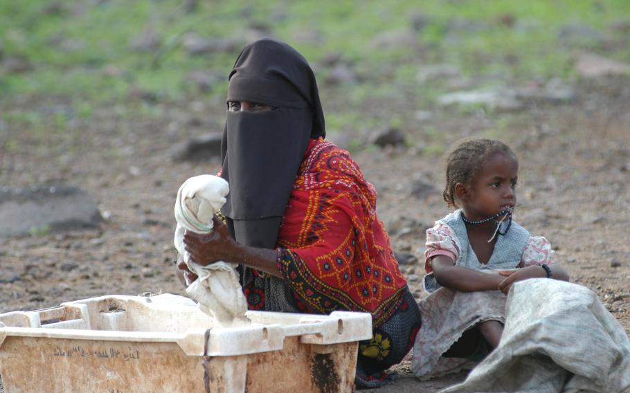 A Djiboutian woman and her child sit in a dry riverbed while their relatives’ goats and camels are tended to by the 412th Civil Affairs Battalion during a civil action program in a remote valley near Tadjoura in Djibouti, Africa. U.S. service members deployed to Camp Lemonier say they hope such civil affairs projects give Djiboutians a good impression of Americans and make them less likely to support terrorists in the Horn of Africa.