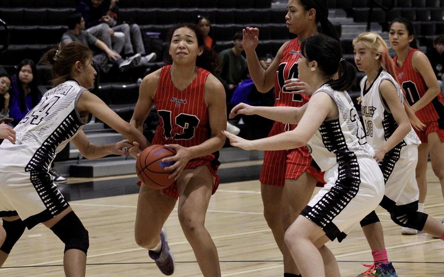 Nile C. Kinnick's Amyka Jones drives between American School Bangkok defenders during Monday's Far East Girls Division I round-robin game, won by the Red Devils 55-21.