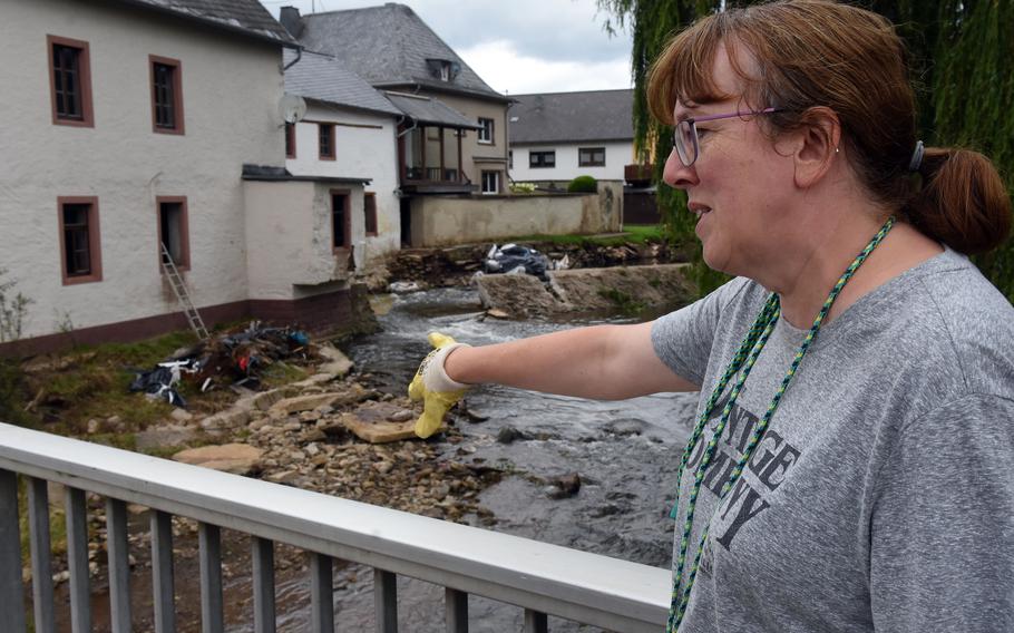 Doris, a resident of Rittersdorf, Germany, who declined to provide her last name, stands on a bridge overlooking her familys mill and a house her family rents to Americans on the banks of the Nims River, July 31, 2021. Both buildings were damaged during historic floods last month. Doris said the river at its peak covered the bridge on which she was standing.