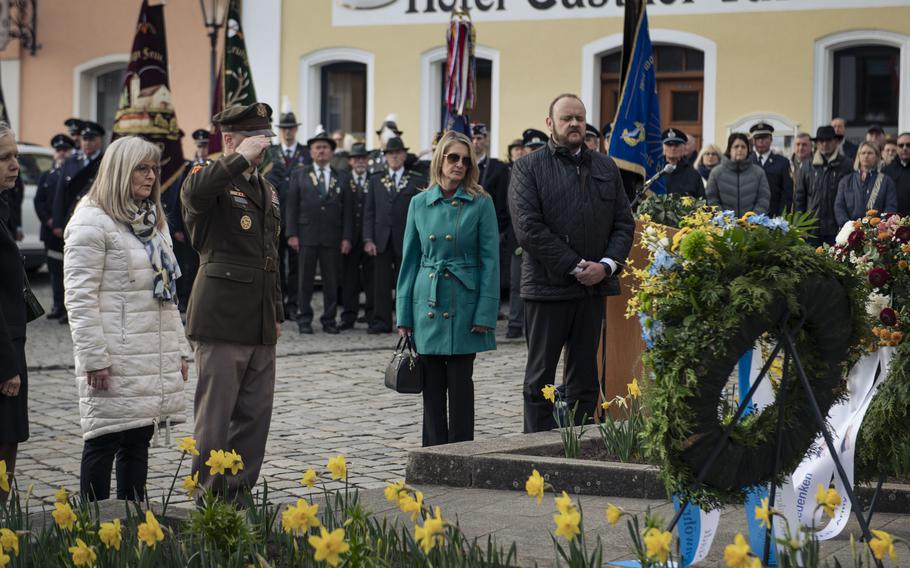 U.S. Army Brig. Gen. Steven Carpenter gives a salute in front of two wreaths.