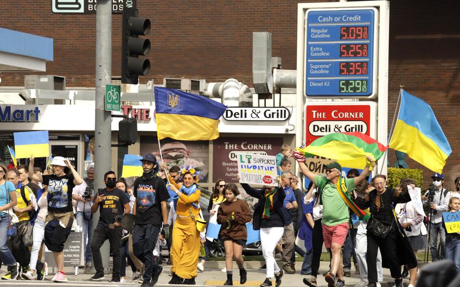Hundreds of Ukrainian Americans and others march past a gas station featuring high prices for gas during a rally to denounce Russia’s invasion of Ukraine along Santa Monica Boulevard in Westwood, Calif., on Feb. 26, 2022.