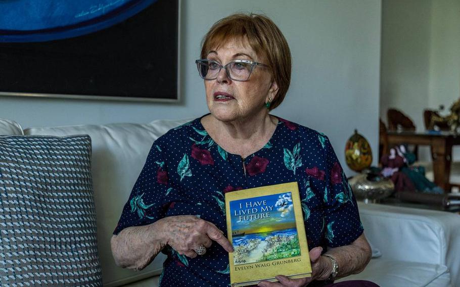 Evelyn Walg Grunberg displays a book she wrote about her family history and their escape from Nazism during the Holocaust in 1942.