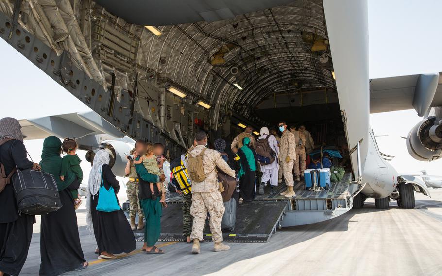 U.S. Marines with the Evacuation Control Center help Afghan evacuees as they board a plane at Al Udeid Air Base, Qatar, Sept. 1, 2021. The Department of Defense is committed to supporting the evacuation of American citizens, Special Immigrant Visa applicants and other at-risk individuals from Afghanistan.