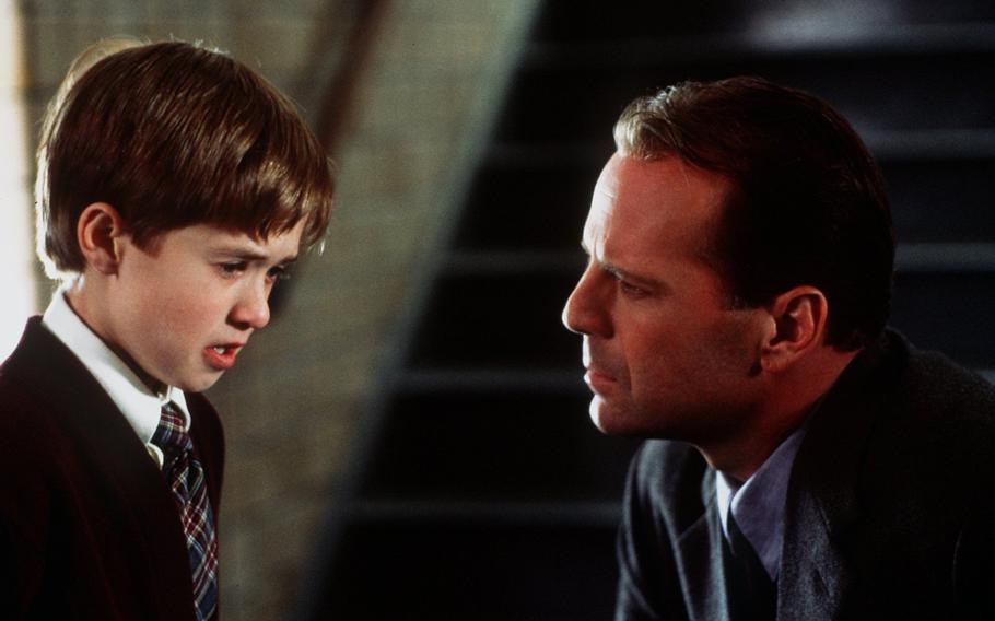 Bruce Willis talks with Haley Joel Osment, left, in a scene from the 1999 M. Night Shyamalan film “The Sixth Sense,” which ushered Willis into the 2000s. Willis also starred in “Unbreakable” and “Glass” for the director.