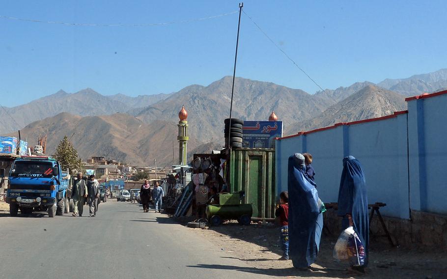 Burka-clad women chat alongside a road through the Panjshir Valley in central Afghanistan in 2016. In a report issued June 10, 2022, Human Rights Watch accuses the Taliban of unlawfully detaining civilians and torturing them for information about opposition fighters.  