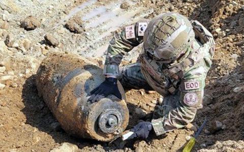 A South Korean air force explosive ordnance disposal specialist inspects an unexploded bomb found at a construction site in Cheongju, South Korea, March 13, 2024.