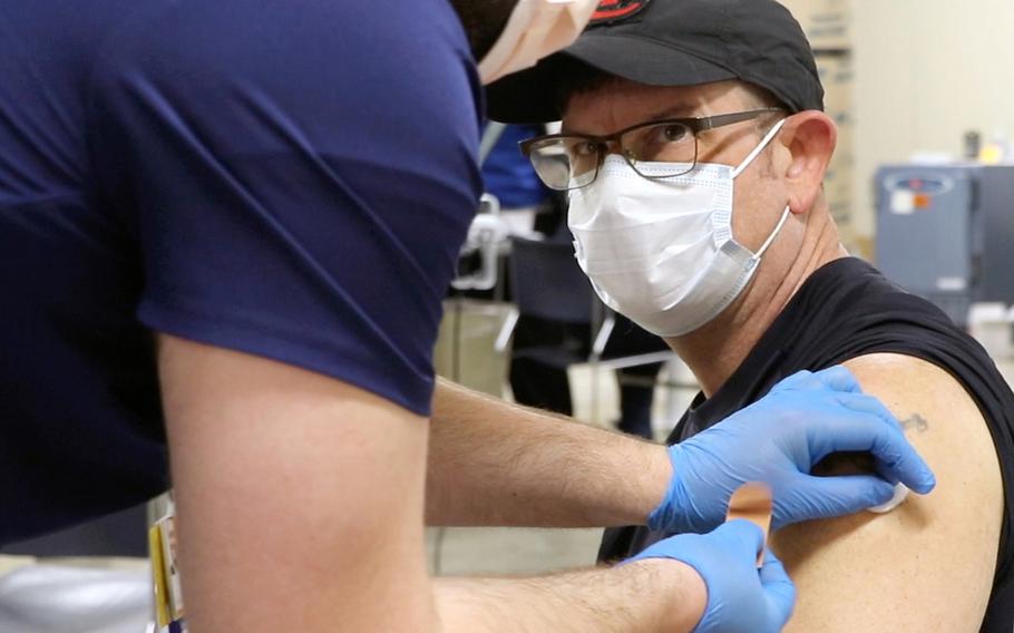 Terry Godfrey, an EMT for the Kansas City Fire Department, receives the Pfizer-BioNTech COVID vaccine at Truman Medical Centers/University Health in Kansas City, Mo. 