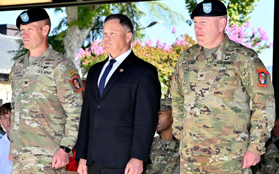 Horrigan and Strong, in uniform, flank Mize, wearing a suit.