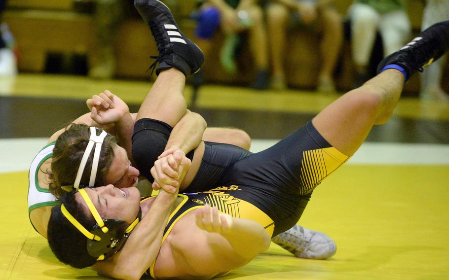 Kubasaki’s Max Lundberg locks in a cradle on Kadena’s Joseph Oh at 148 pounds during Wednesday’s Okinawa wrestling dual meet. Lundberg won by pin in 2 minutes, 39 seconds and the Dragons took the meet 40-23.