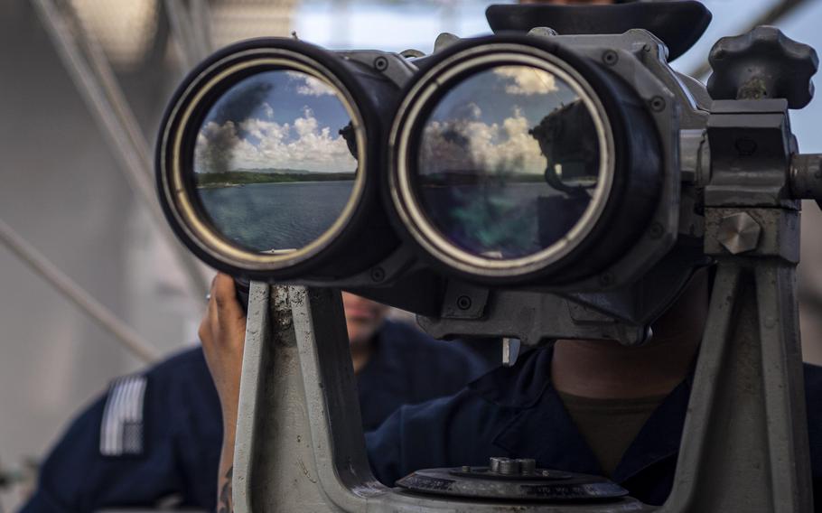 A person looks through binoculars.