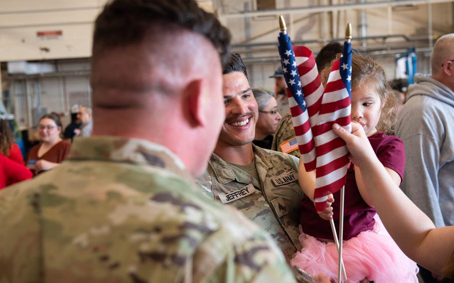 Family members of Task Force Tomahawk soldiers hold up signs at the welcome home ceremony at Will Rogers Air National Guard Base in Oklahoma City, Feb. 22, 2024. 