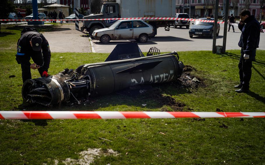 A partly damaged rocket with sign in Russian "for the children" lays in front of the train station on Friday.