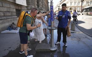 People use a street water fountain during a heat wave, Monday, June 30, 2025 in Paris. (AP Photo/Christophe Ena)