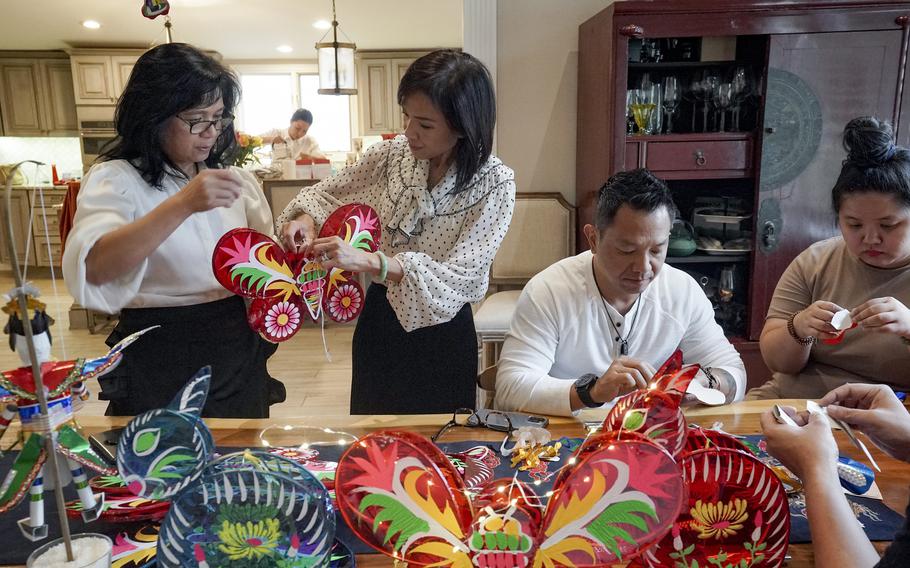Erin Phuong Steinhauer, second from left, at her home in Falls Church, Va., on Sept. 26, 2023, with her sister, Thu Pham, from left, her brother, Cuong Pham, and Quan Lam, as they prepare to celebrate Vietnam Week.