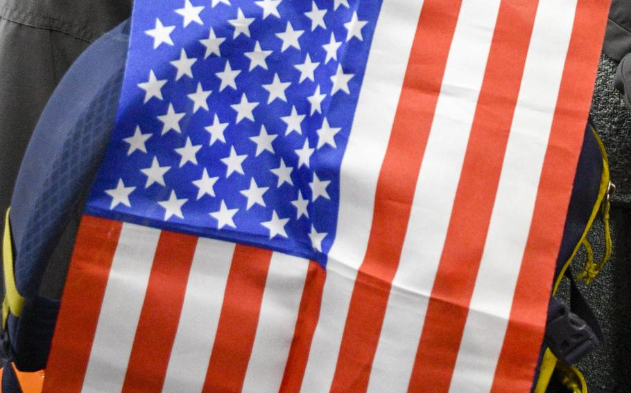 A U.S. Embassy employee awaiting a flight out of Afghanistan on Sunday, Aug. 15, 2021, shows an American flag he saved while leaving the compound in Kabul the previous day. 