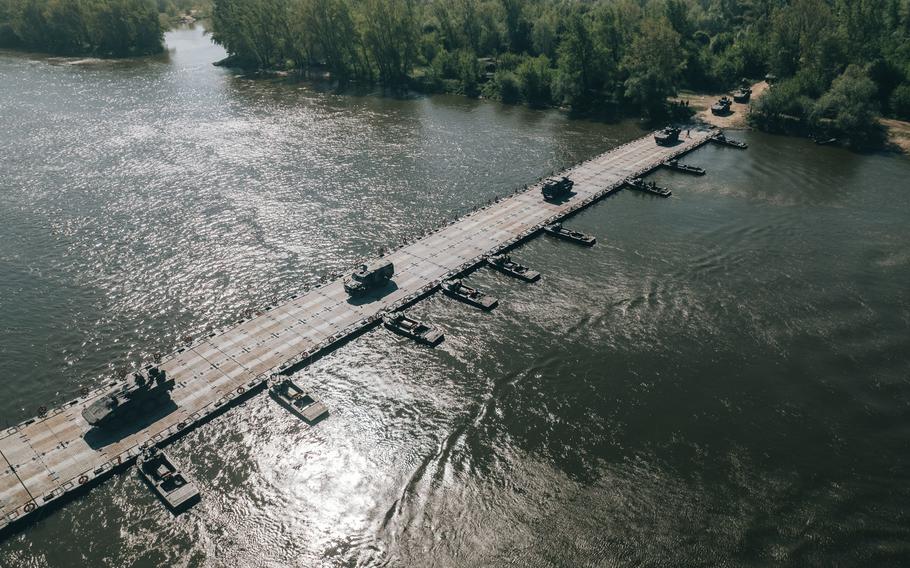 Military vehicles roll over a float ribbon bridge system set up by the 74th Multi-Role Bridge Company, deployed from Fort Hood, Texas, to cross the Vistula River between Ryki and Kozienice, Poland, May 13, 2022. 