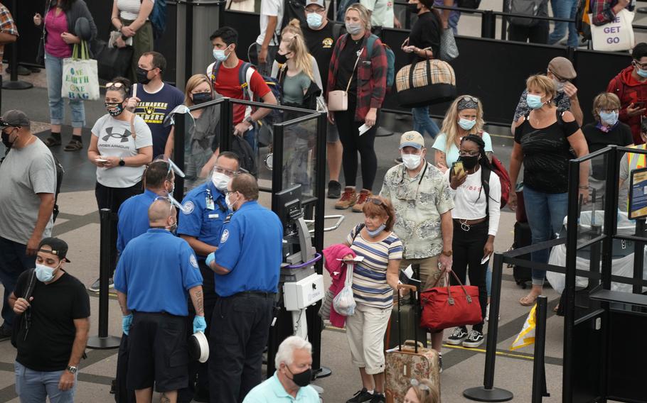  Travelers wear face coverings in the line for the south north security checkpoint in the main terminal of Denver International Airport Tuesday, Aug. 24, 2021, in Denver. 