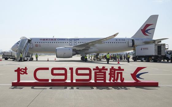 In this photo released by Xinhua News Agency, a sign which reads "1st C919 inaugural flight" is seen in front of the Chinese made passenger aircraft prepared for its first commercial flight from Shanghai on Sunday, May 28, 2023. China’s first domestically made passenger jet flew its maiden commercial flight on Sunday, as China looks to compete with companies such as Boeing and Airbus in the global aircraft market.(Ding Ting/Xinhua via AP)