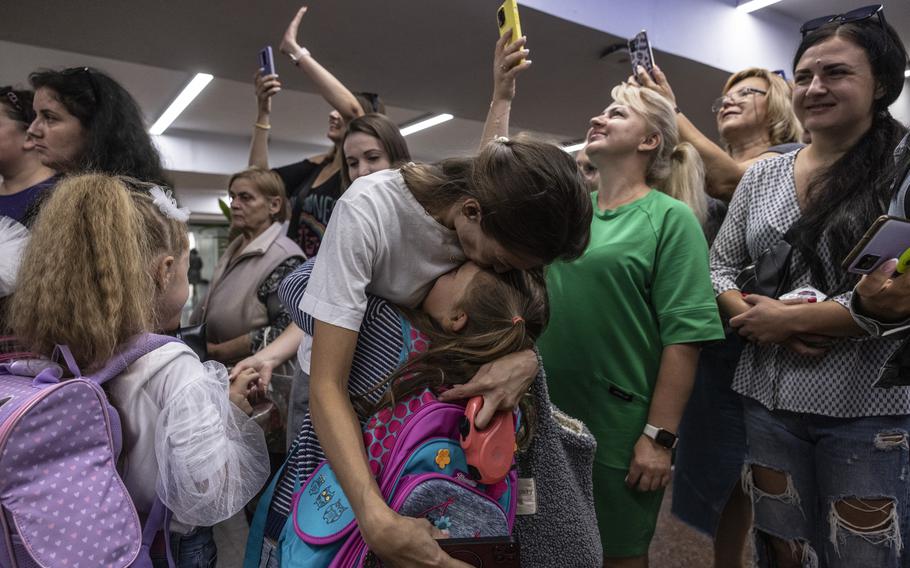 Mothers welcome their children coming out of school on the first day of classes held in the underground metro station in Kharkiv, Ukraine, on Monday, Sept. 4, 2023.