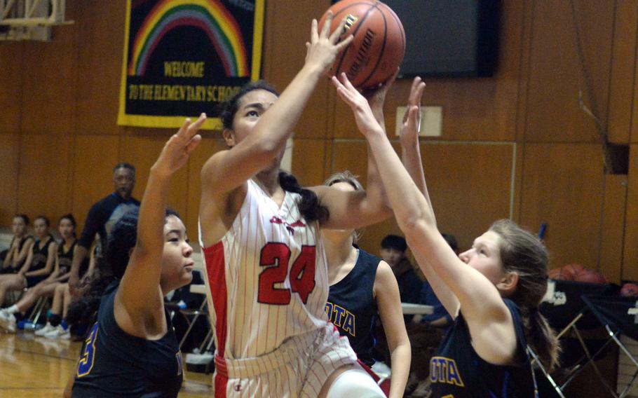 Nile C. Kinnick's Kotone Turner shoots between two Yokota defenders during Friday's ASIJ Kanto Classic quarterfinal. The Red Devils won 40-15 to stay unbeaten at 16-0. They face Okkodo of Guam in Saturday's semifinal.