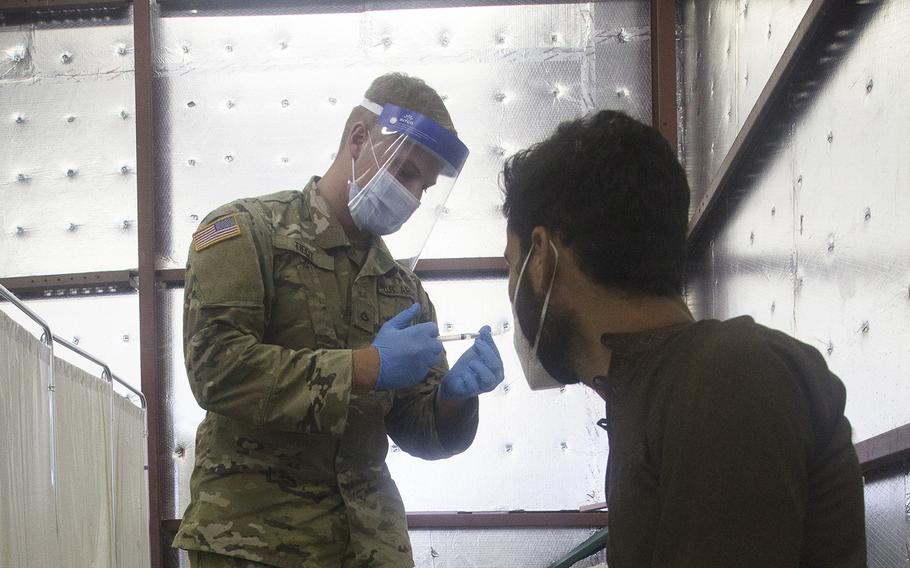 A member of the Wisconsin National Guard prepares a COVID vaccination dose for an Afghan evacuee at Fort McCoy, Wis., on Sept. 3, 2021. According to a report on Wednesday, Nov. 23, 2022, roughly 58 percent of coronavirus deaths in August were people who were vaccinated and/or boosted.