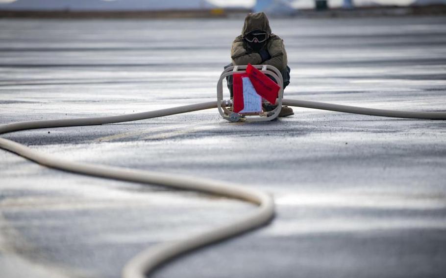 Seaman Stanton Smith of Navy Cargo Handling Battalion checks the fuel meter wile refueling a plane during the Northern Viking 22 exercise on Keflavik Air Base in Iceland.