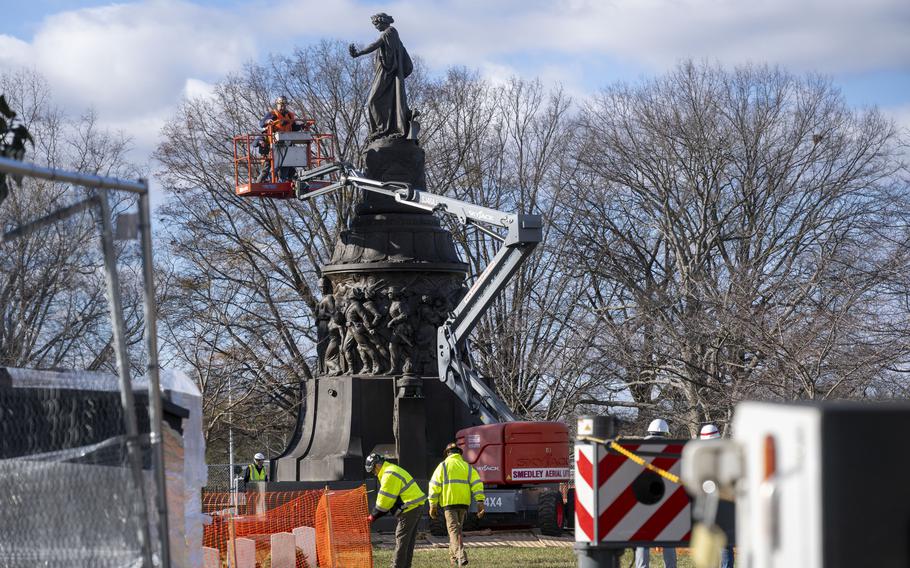 Workers prepare a Confederate Memorial for removal in Arlington National Cemetery on Dec. 18.