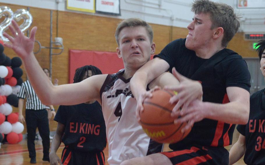 E.J. King's Jacob Auger comes down with a rebound in front of Matthew C. Perry's Ryan Livengood during Saturday's DODEA-Japan boys basketball game. The Samurai won 62-55.