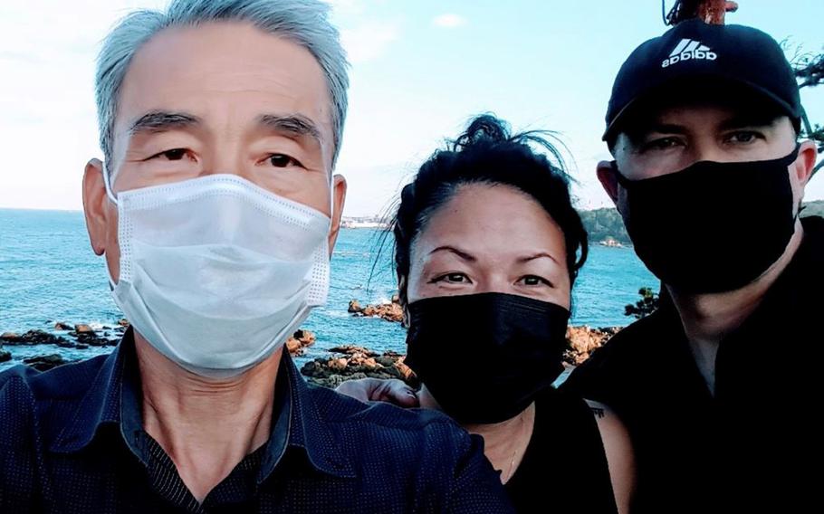 Tara Graves poses between her husband, Army Col. Seth Graves, right, and her birth brother, Kim Hyung-bae, during a recent reunion in South Korea. 