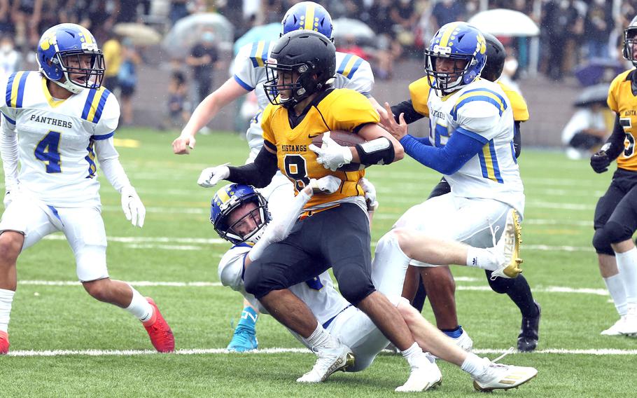 American School In Japan's Stefan Merino is brought down by Yokota's Michael Kasten during Saturday's rain-drenched Kanto Plain football game at Mustang Valley. The Mustangs led 14-6 with 9:42 left when the game was called due to lightning and rescheduled for Oct. 28 at Yokota.