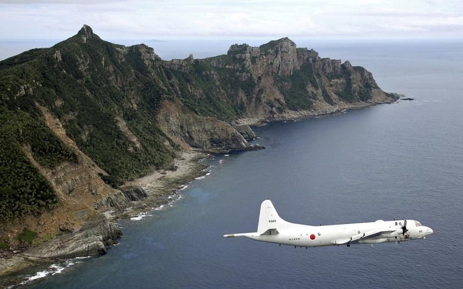 Japan Maritime Self-Defense Force P-3C Orion surveillance plane flies over the disputed islands.