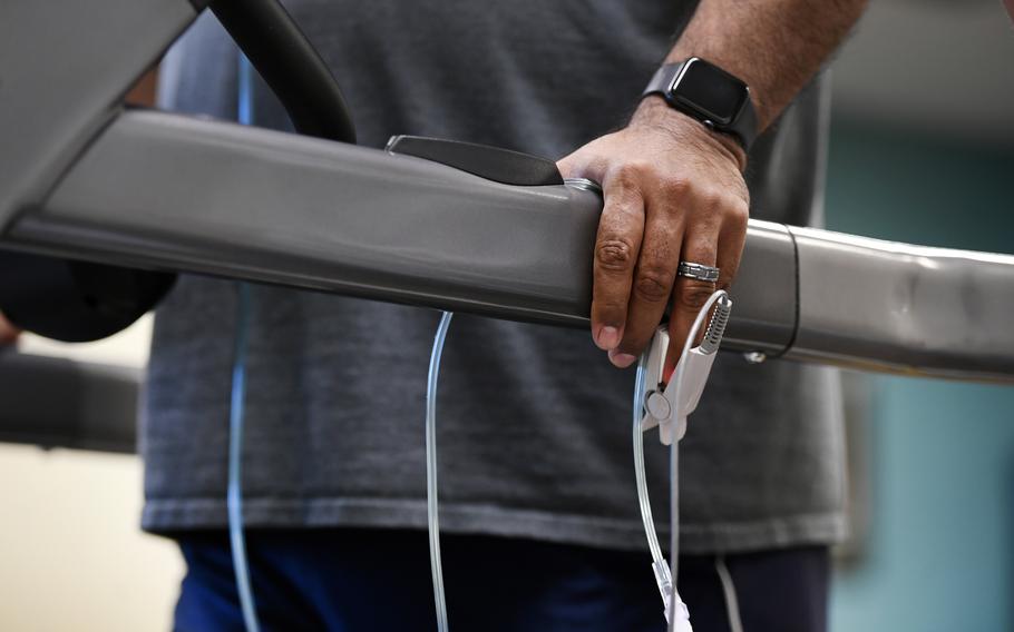 A patient suffering from lingering symptoms of COVID-19 wears a pulse oximeter to keep track of his oxygen intake as he works out on the treadmill during physical therapy at National Jewish Health on March 3, 2021, in Denver.