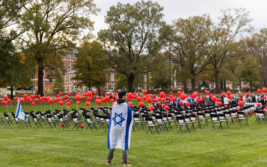 A student looks at photographs of people taken hostage by Hamas, in a display on the University of Maryland’s McKeldin Mall on Nov. 9. 