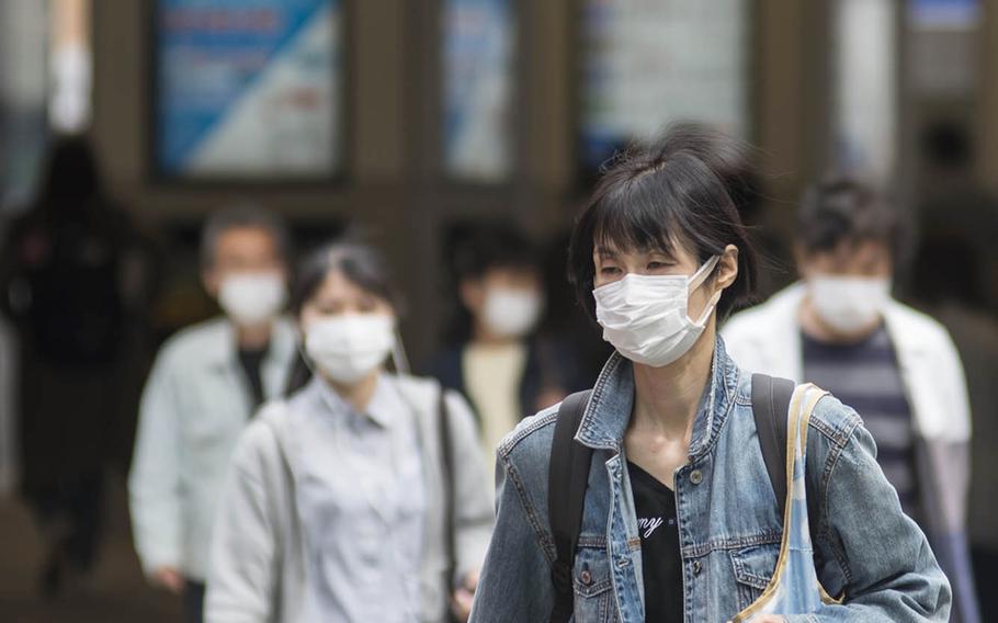 People walking near Tsunashima Station wear masks to prevent coronavirus infection earlier this spring in Yokohama, Japan.