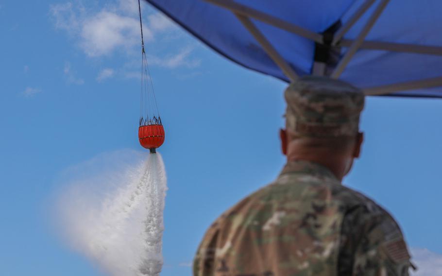Hawaii Air National Guard Staff Sgt. Joseph Ragocos Jr., a security forces noncommissioned officer assigned to the 154th Security Forces Squadron, secures the area as an Army CH-47 Chinook on Wednesday, Aug. 16, 2023, drops seawater around the perimeter of the area impacted by the wildfires at Lahaina, Maui.